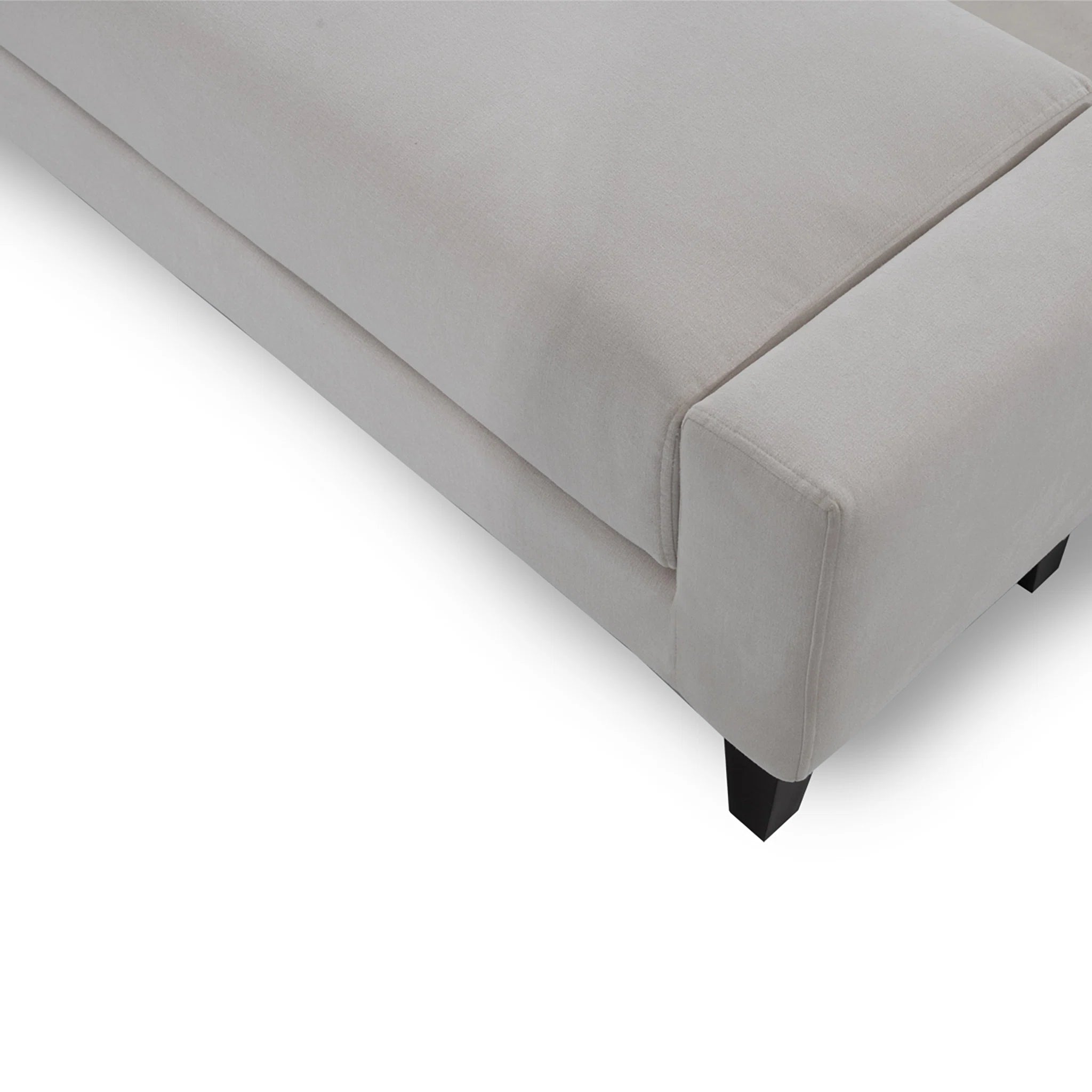 Gray upholstered bed corner on a white background