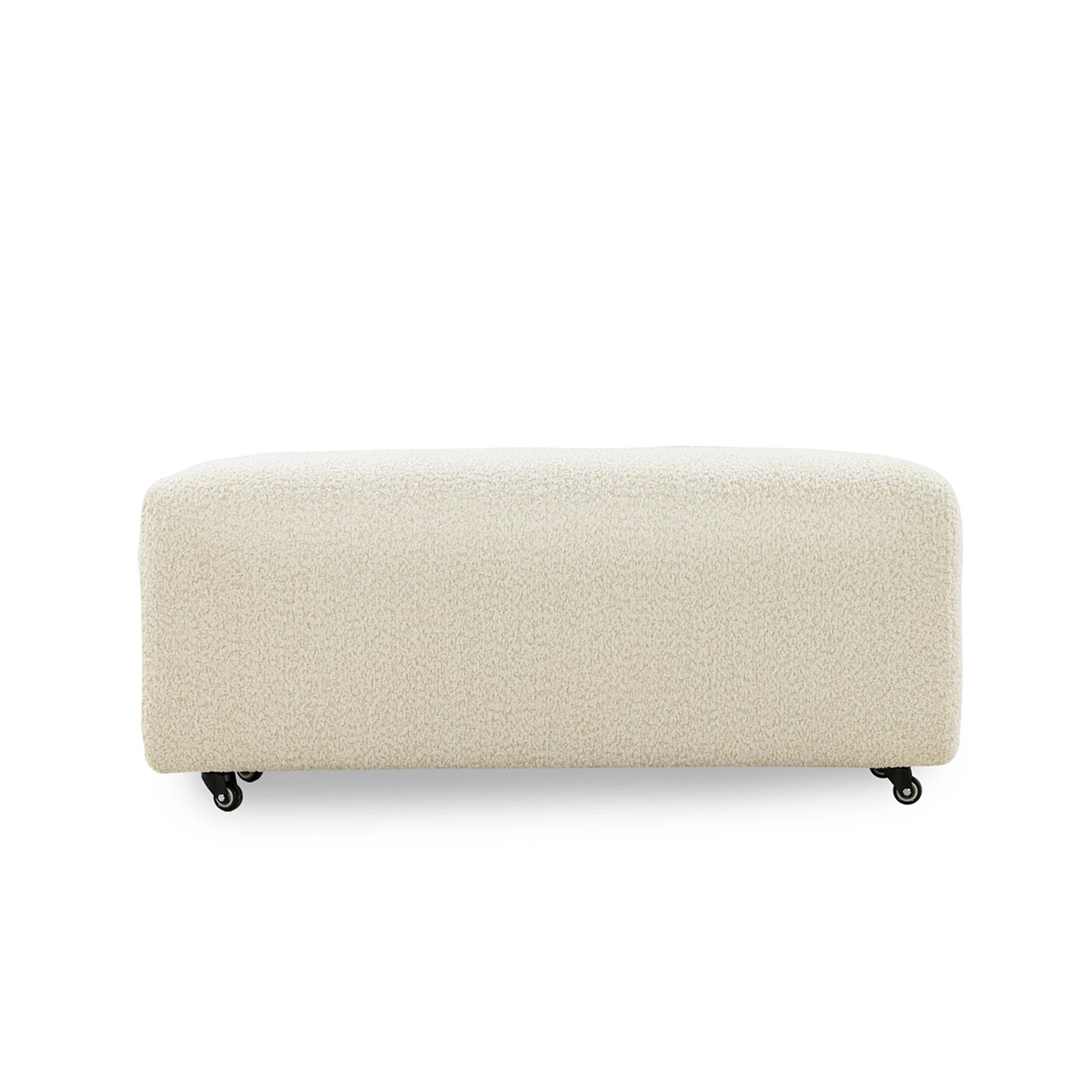 Beige upholstered bench on wheels with a textured surface on a white background