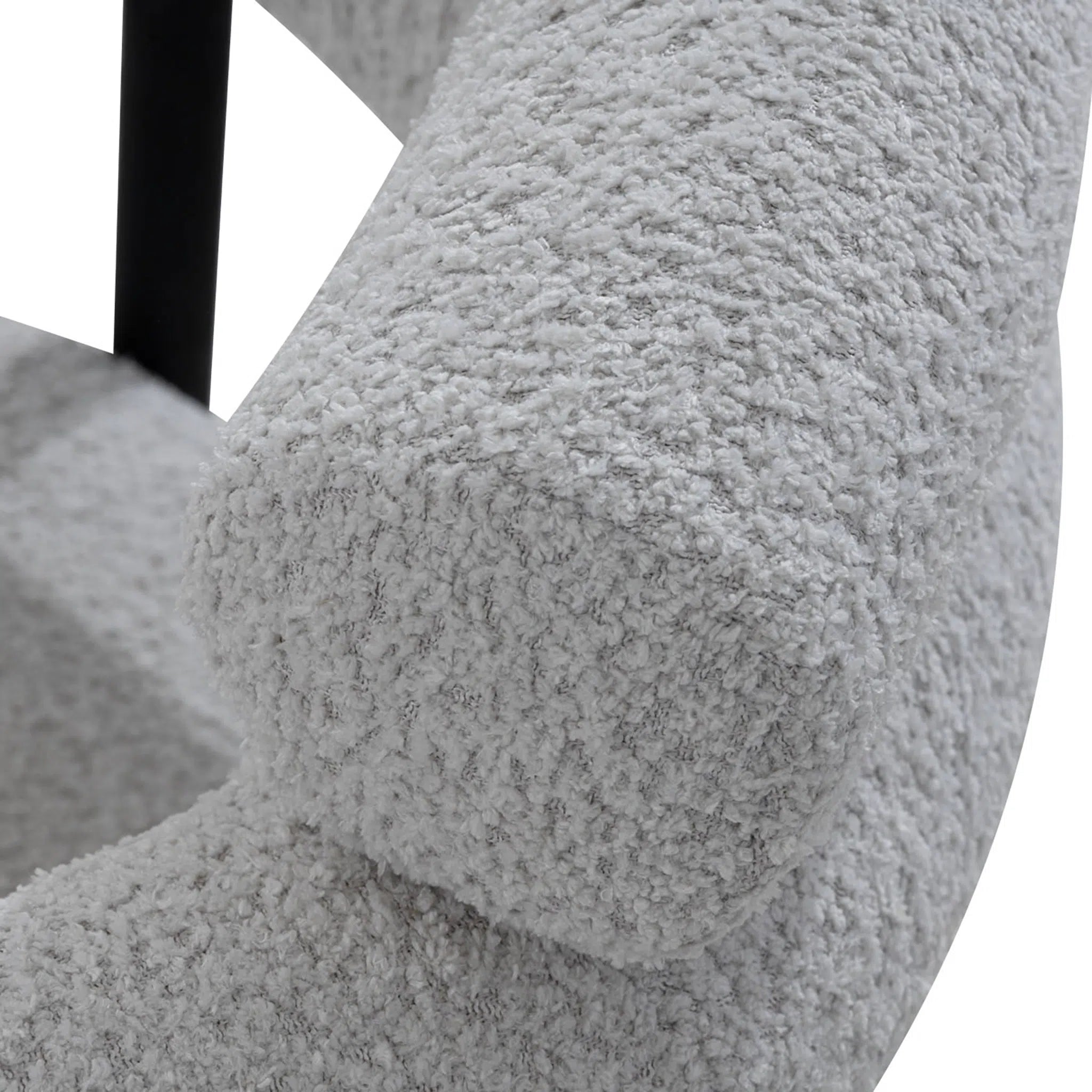 Close-up of a textured gray chair armrest with a white background