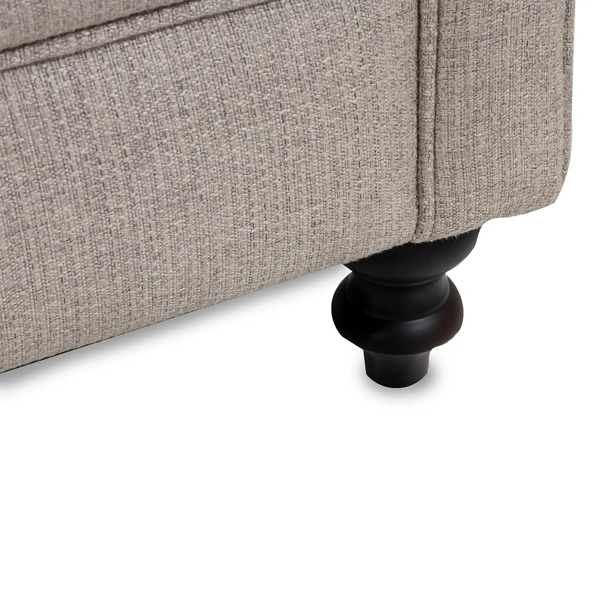 Close-up of a textured beige sofa corner with a black leg on a white background