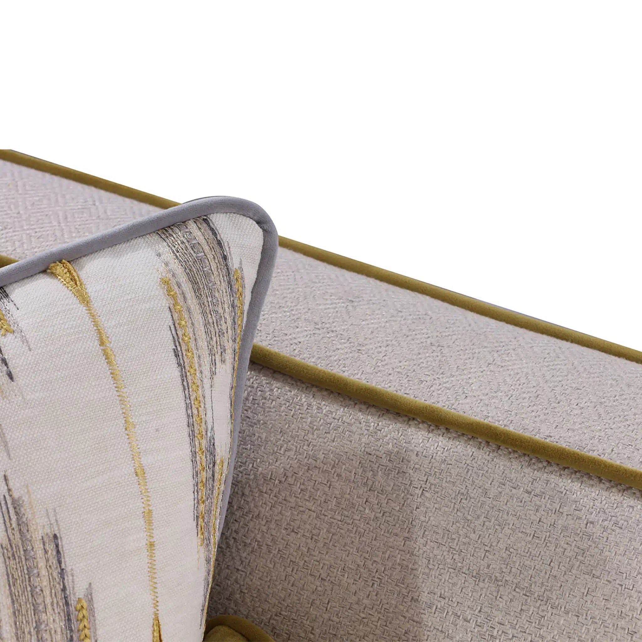 Close-up of a textured fabric surface with a gold line and patterned edge.