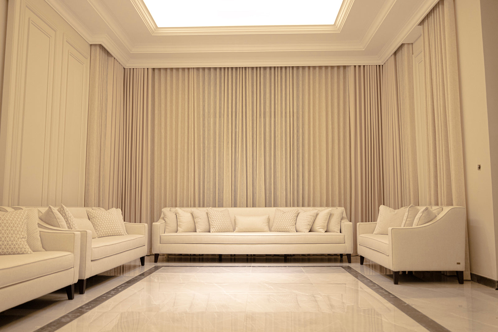 Beige living room with white sofas and striped curtains