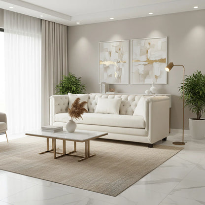 Modern living room with a white sofa, coffee table, and abstract art on the wall.