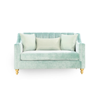 Light blue sofa with three pillows on a white background