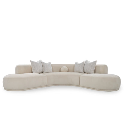 Beige curved sofa with decorative pillows on a white background