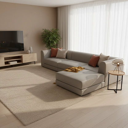Modern living room with a gray sectional sofa, coffee table, and TV stand.