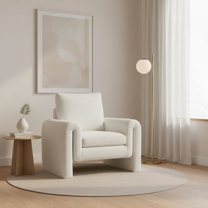 White armchair in a modern living room with a side table and lamp.