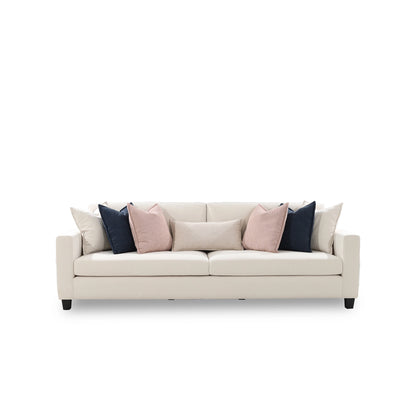 Beige sofa with pink and blue cushions on a white background