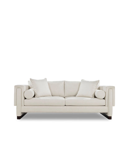 Beige sofa with three cushions on a white background