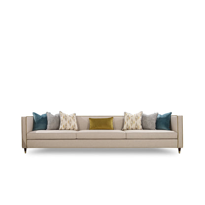 Beige sofa with decorative pillows on a white background