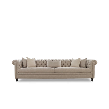 Beige sofa with tufted backrest and four cushions on a white background