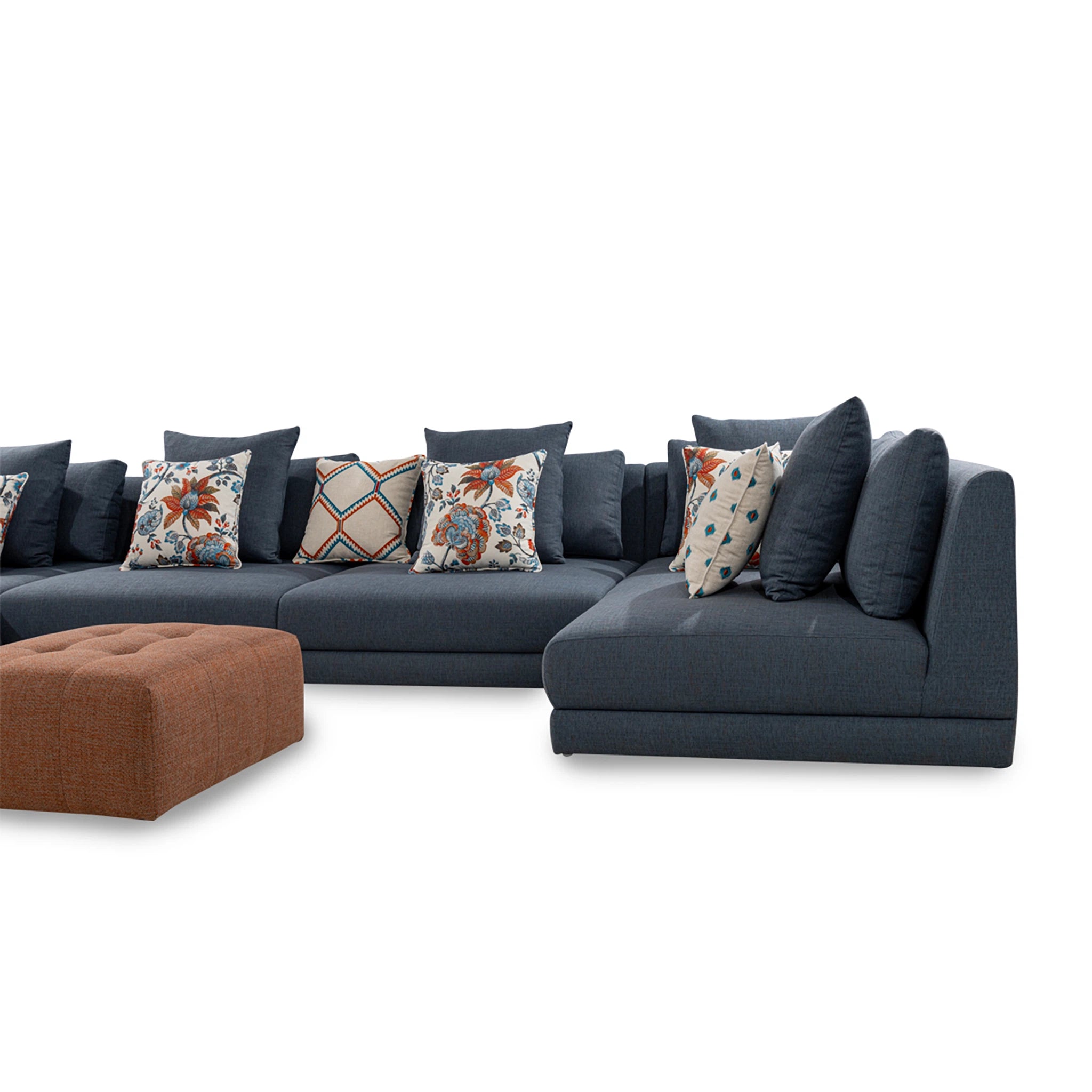 Gray sectional sofa with patterned cushions and a brown ottoman on a white background