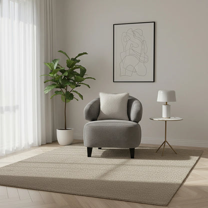 Modern living room with a gray armchair, plant, and abstract art on the wall.