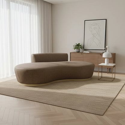 Modern living room with a brown abstract sofa, wooden side table, and framed artwork.