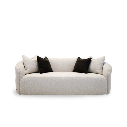 Beige sofa with black and white cushions on a white background