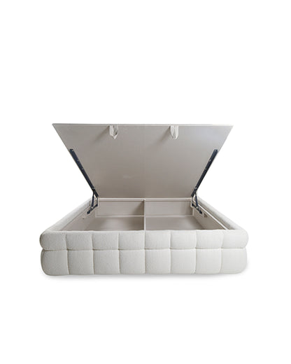 White upholstered bed with open headboard on a white background