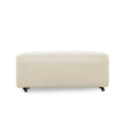 Beige upholstered bench on wheels with a textured surface on a white background