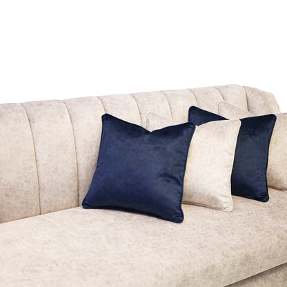 Navy blue pillows on a beige sofa against a white background