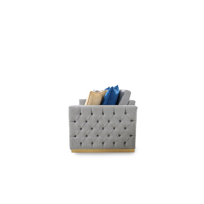 Gray tufted ottoman with decorative pillows on a white background