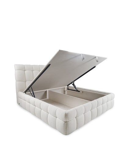 White tufted storage ottoman with open lid on a white background
