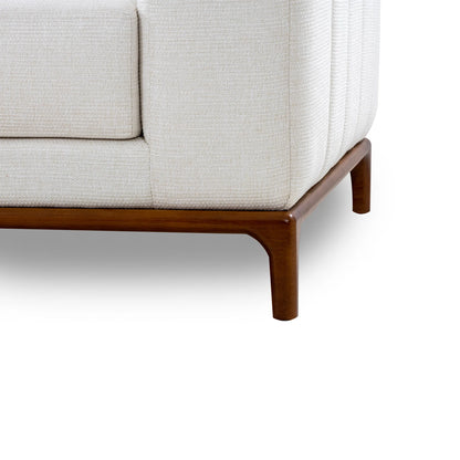 Close-up of a beige sofa with wooden legs on a white background