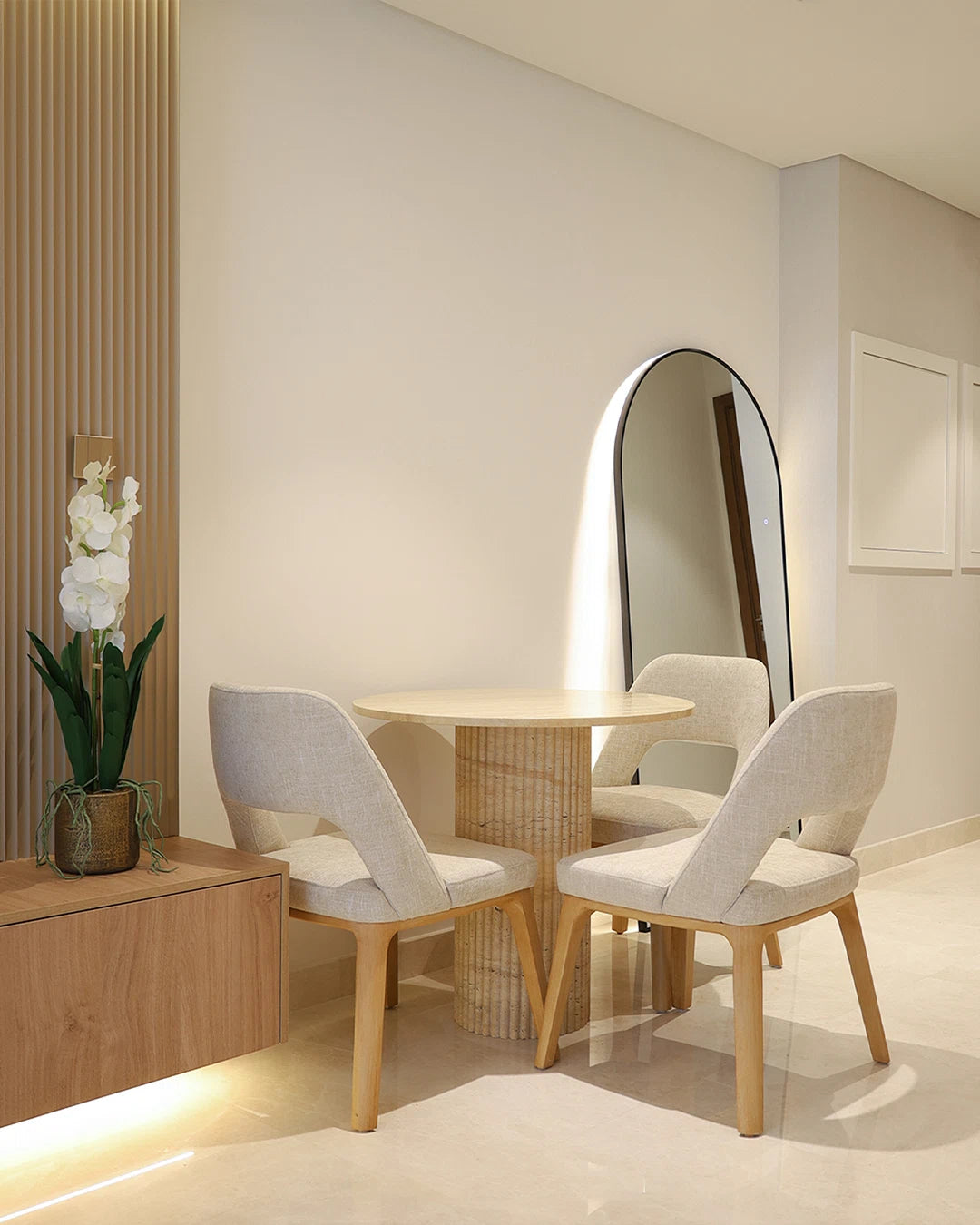 Modern dining area with round table and chairs in a well-lit room.