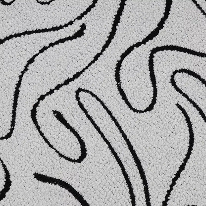Close-up of a textured surface with black wavy patterns on a gray background