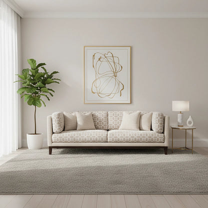 Living room with a patterned sofa, plant, and abstract art on the wall.