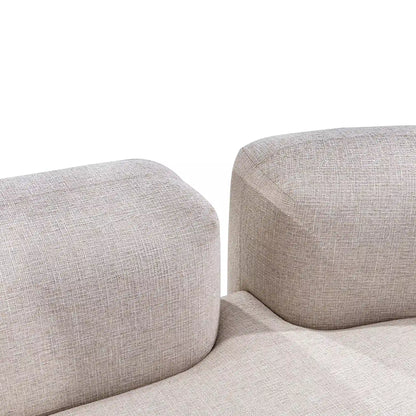 Close-up of a beige fabric sofa with a plain white background