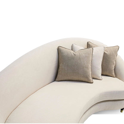 Beige curved sofa with decorative pillows on a white background