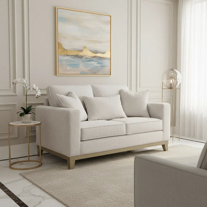 Beige sofa in a living room with abstract art and side table.