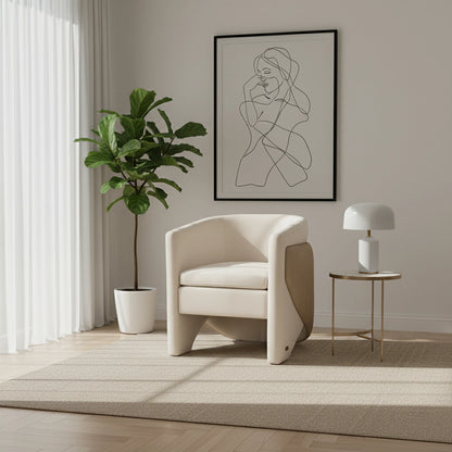 Modern living room with a beige armchair, potted plant, and framed artwork.