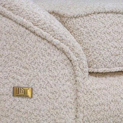 Close-up of a textured beige fabric with a gold label on a matching background