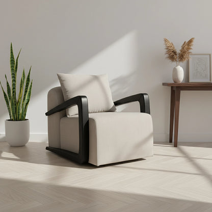 White armchair with black armrests in a room with a plant and small table.