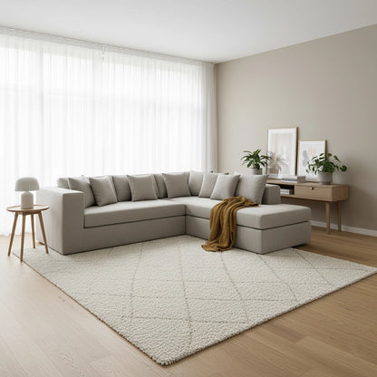 Modern living room with a beige sectional sofa, rug, and side table.