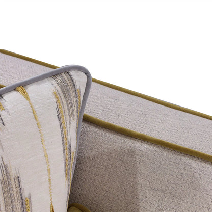 Close-up of a textured fabric surface with a gold line and patterned edge.